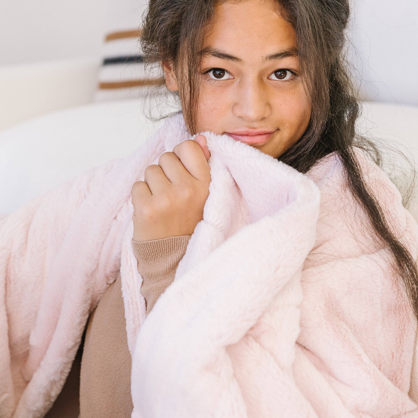 Woman wrapped in the Blossom Pink Posh minky blanket from Minky Designs, highlighting its soft, plush texture and cozy warmth.